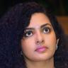 Parvathy Thiruvothu with curly hair and a bindi, close-up portrait