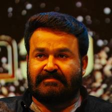 Mohanlal with a beard in a dark shirt at an event