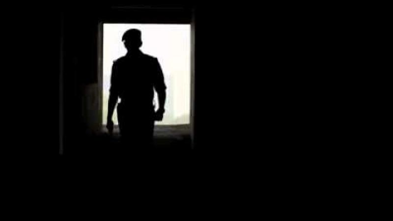 A silhouetted police officer standing in a doorway in the Mumbai Police trailer