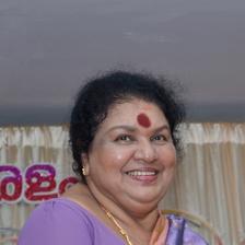Kaviyoor Ponnamma smiling in a purple saree at an event