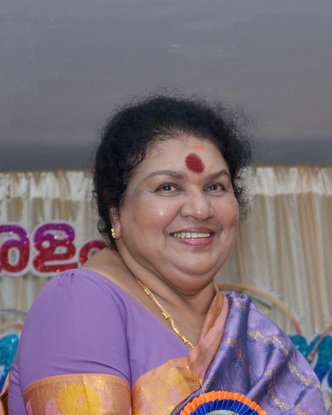 Kaviyoor Ponnamma smiling in a purple saree at an event