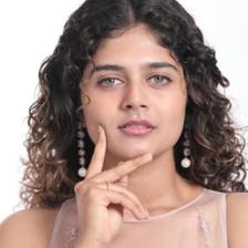 Aiswarya Raj with curly hair resting her chin on her hand
