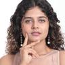 Aiswarya Raj with curly hair resting her chin on her hand