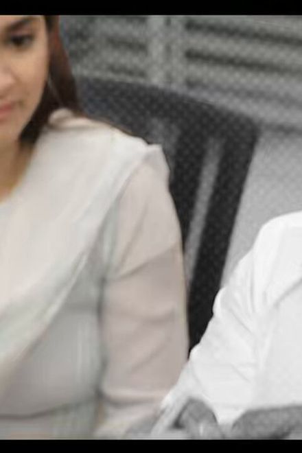 Keerthy Suresh in a white churidar gesturing as she talks to a bearded man in a white shirt at a table, black-and-white teaser still from Sathyavan Savithiri