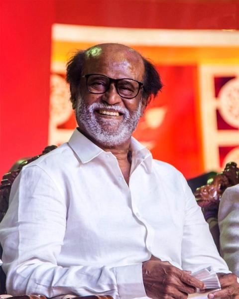 Rajinikanth smiling in a white shirt at an event