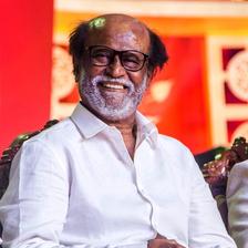 Rajinikanth smiling in a white shirt at an event