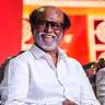 Rajinikanth smiling in a white shirt at an event