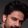 Jaideep Ahlawat with a beard looking at the camera, close-up portrait