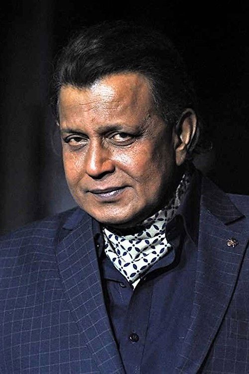 Mithun Chakraborty in a dark suit and patterned scarf, portrait