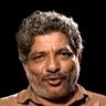 Jaffer Idukki with grey curly hair and a moustache in a khaki shirt, portrait