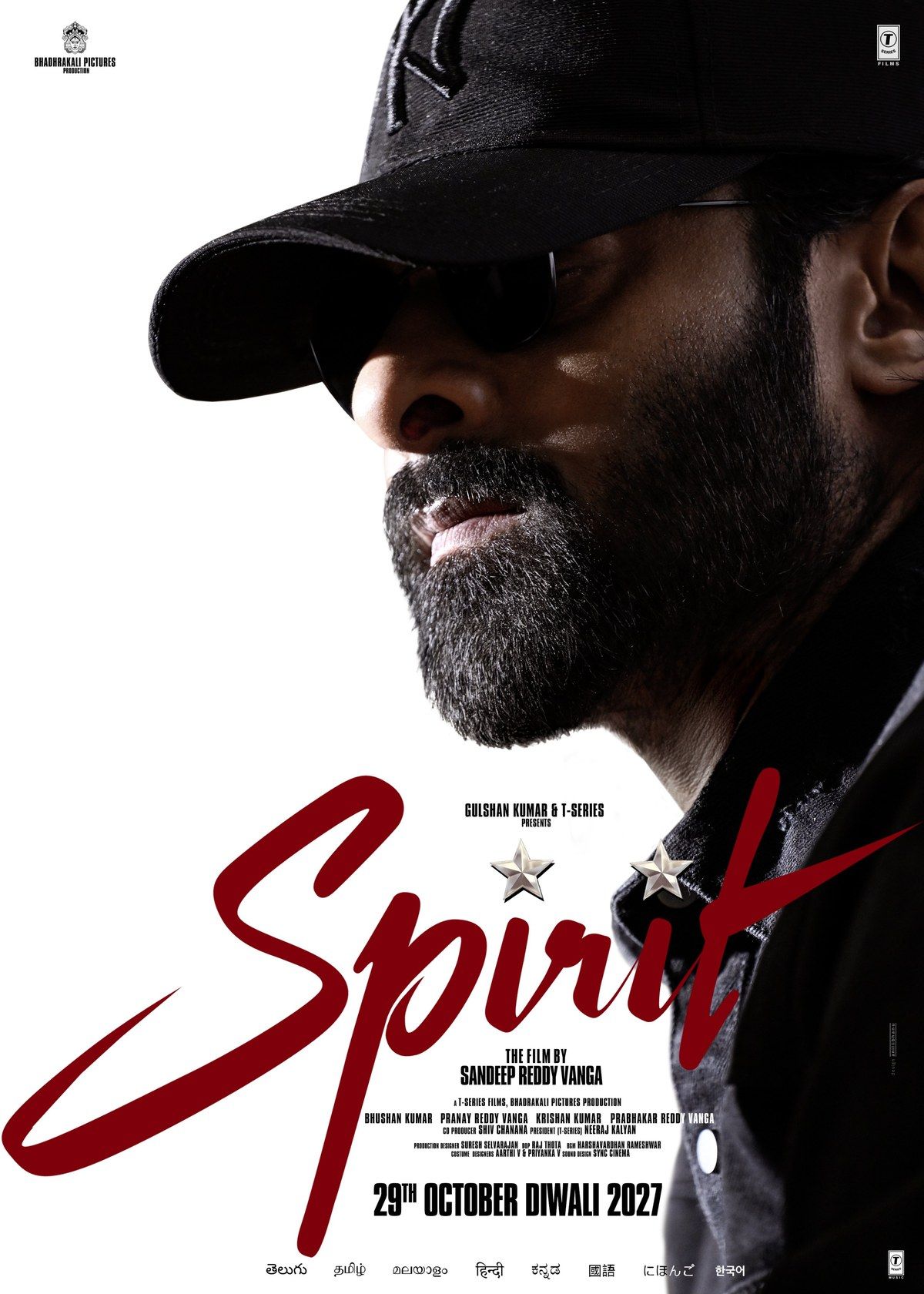 Spirit poster showing Prabhas in profile in a black cap and dark glasses, with a salt-and-pepper beard, above the red Spirit title and the 29th October Diwali 2027 release date