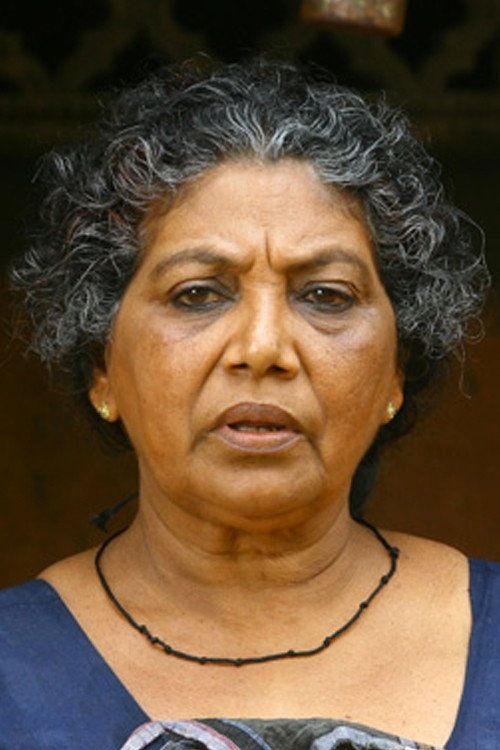 Santhakumari with curly grey hair and a black necklace, close-up