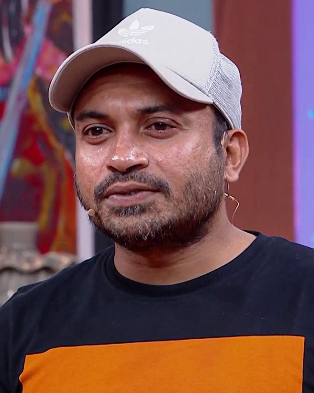 Soubin Shahir in a white cap and black T-shirt, smiling