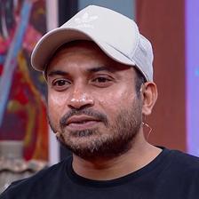 Soubin Shahir in a white cap and black T-shirt, smiling