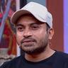 Soubin Shahir in a white cap and black T-shirt, smiling