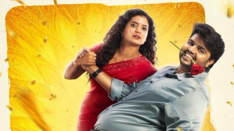 Anna Ben in a red saree holding Kishore Rajkumar, who has a red rose in his mouth, in the Coimbatore Mappillaii poster