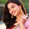 Mamitha Baiju smiling in a pink saree with gold earrings