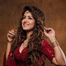 Ishita Dutta posing in a red sequinned outfit with long wavy hair