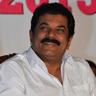 Mukesh in a white shirt seated at an event, portrait