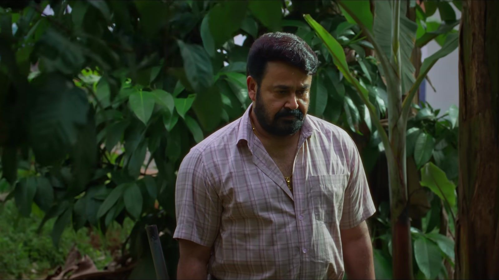Mohanlal as Georgekutty in a checked shirt among banana plants in the Drishyam 3 trailer