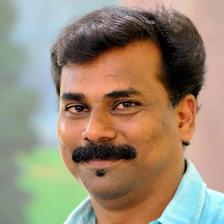 Sajeev Pazhoor with a moustache in a blue shirt, portrait
