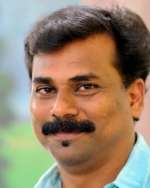 Sajeev Pazhoor with a moustache in a blue shirt, portrait