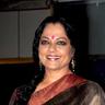 Tanvi Azmi smiling in a brown silk sari with a red border at an event