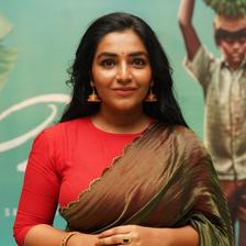 Rajisha Vijayan in a red blouse and saree, half-length portrait