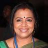 Poornima Bhagyaraj smiling in a green saree with a lanyard