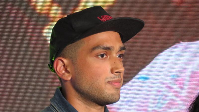 Kalidas Jayaram in a black cap and denim jacket at an event