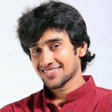 Dhruvan smiling in a maroon shirt against a white background