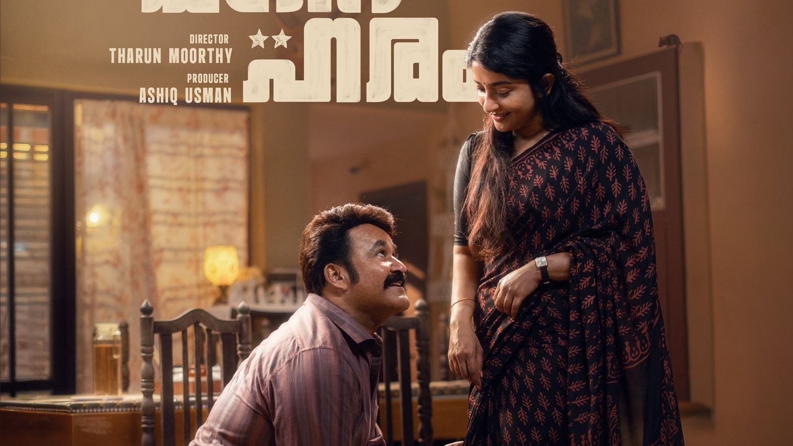 Mohanlal kneels and looks up at a smiling Meera Jasmine in an official Athimanoharam poster