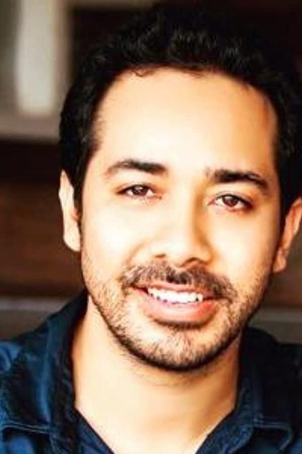Abhishek Pathak smiling in a dark shirt, close-up portrait