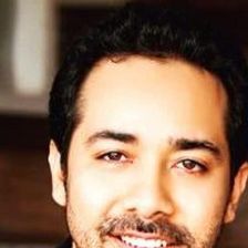 Abhishek Pathak smiling in a dark shirt, close-up portrait