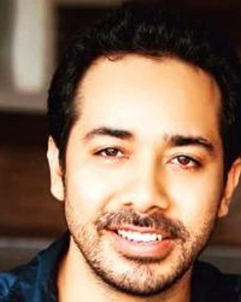 Abhishek Pathak smiling in a dark shirt, close-up portrait