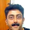 Ashokan with a moustache in a dark printed shirt, close-up portrait