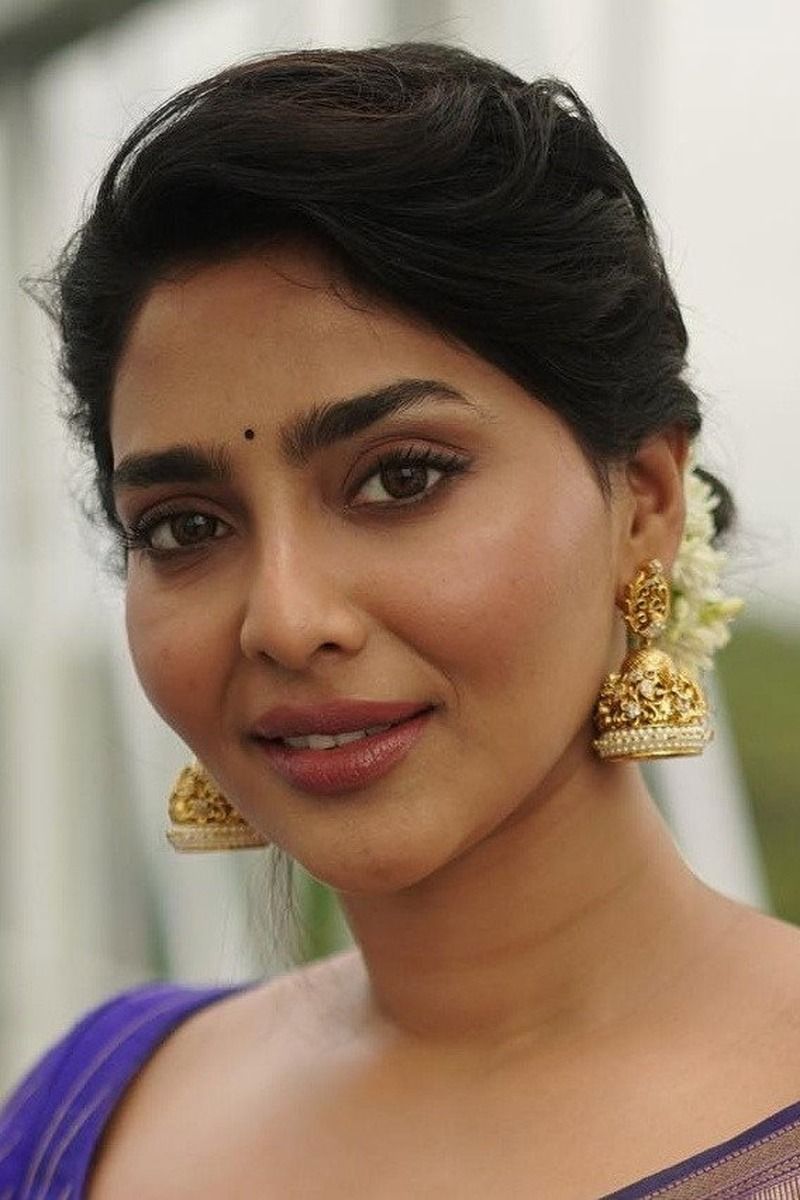 Aishwarya Lekshmi smiling in gold jhumka earrings, close-up portrait