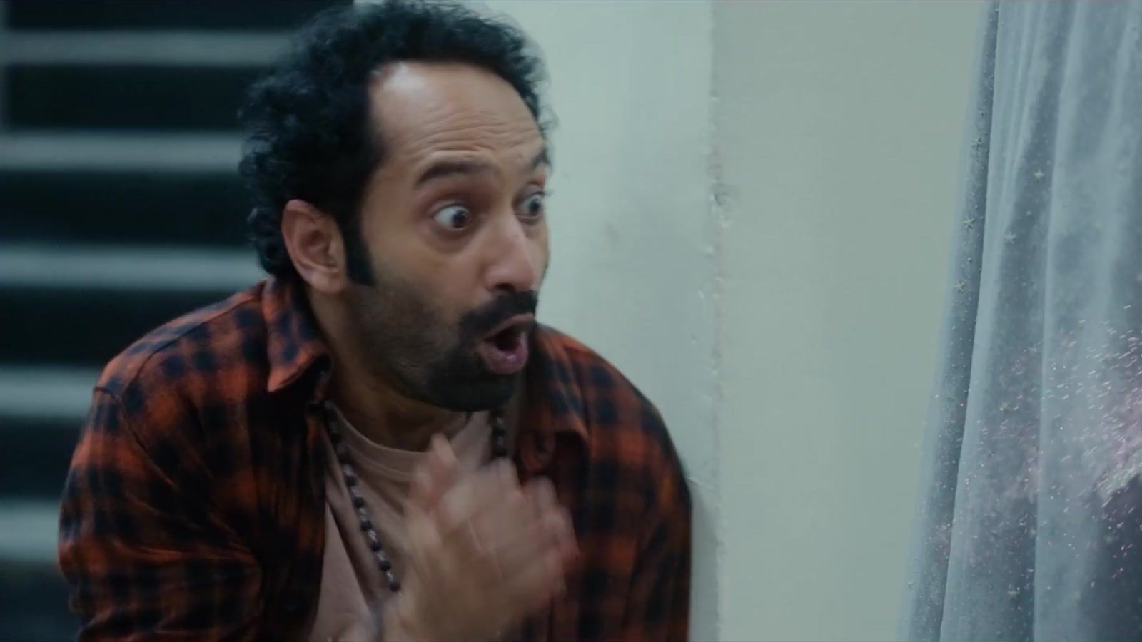 Fahadh Faasil as Suri, wide-eyed in a red check shirt, in the Don't Trouble the Trouble trailer