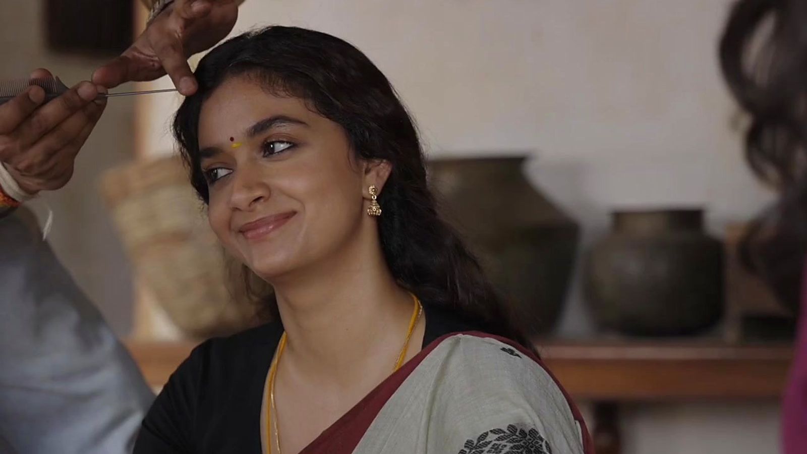 Keerthy Suresh smiling in a saree on the set of Dorothy