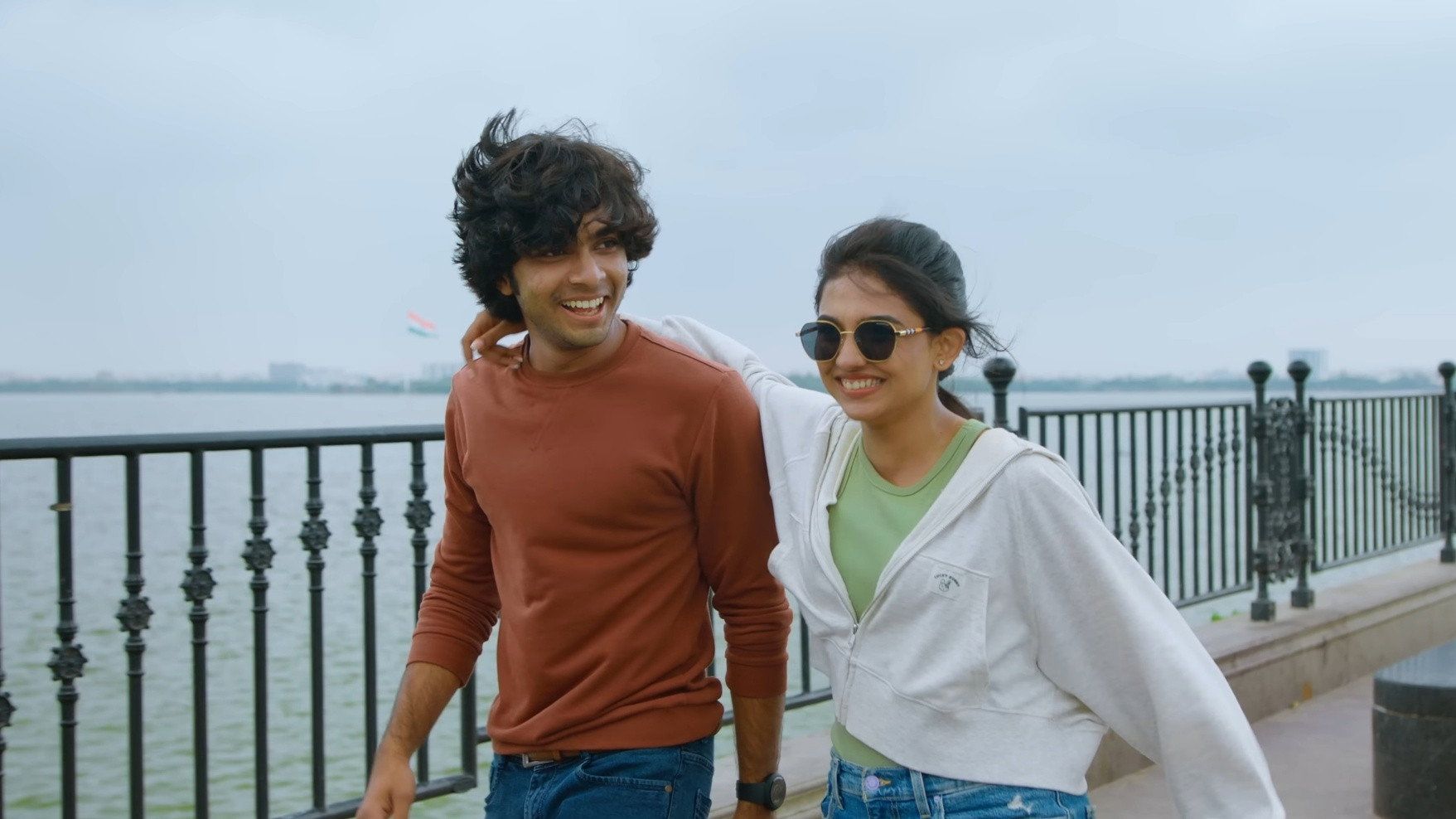 Premalu still of Naslen and Mamitha Baiju laughing by a seaside railing