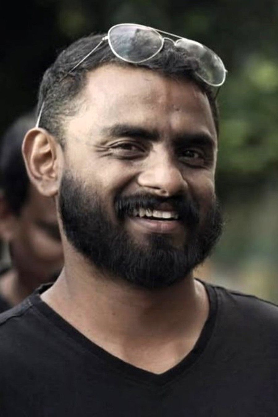 Jithin K Jose with a beard and sunglasses on his head in a black T-shirt, smiling