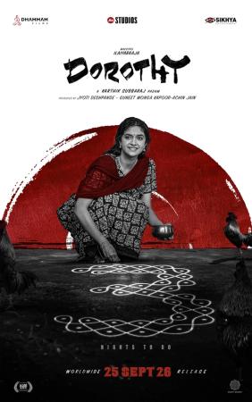 Dorothy poster showing Keerthy Suresh in a red-and-black saree, smiling as she draws a kolam on the ground, with roosters around her and a red sun behind