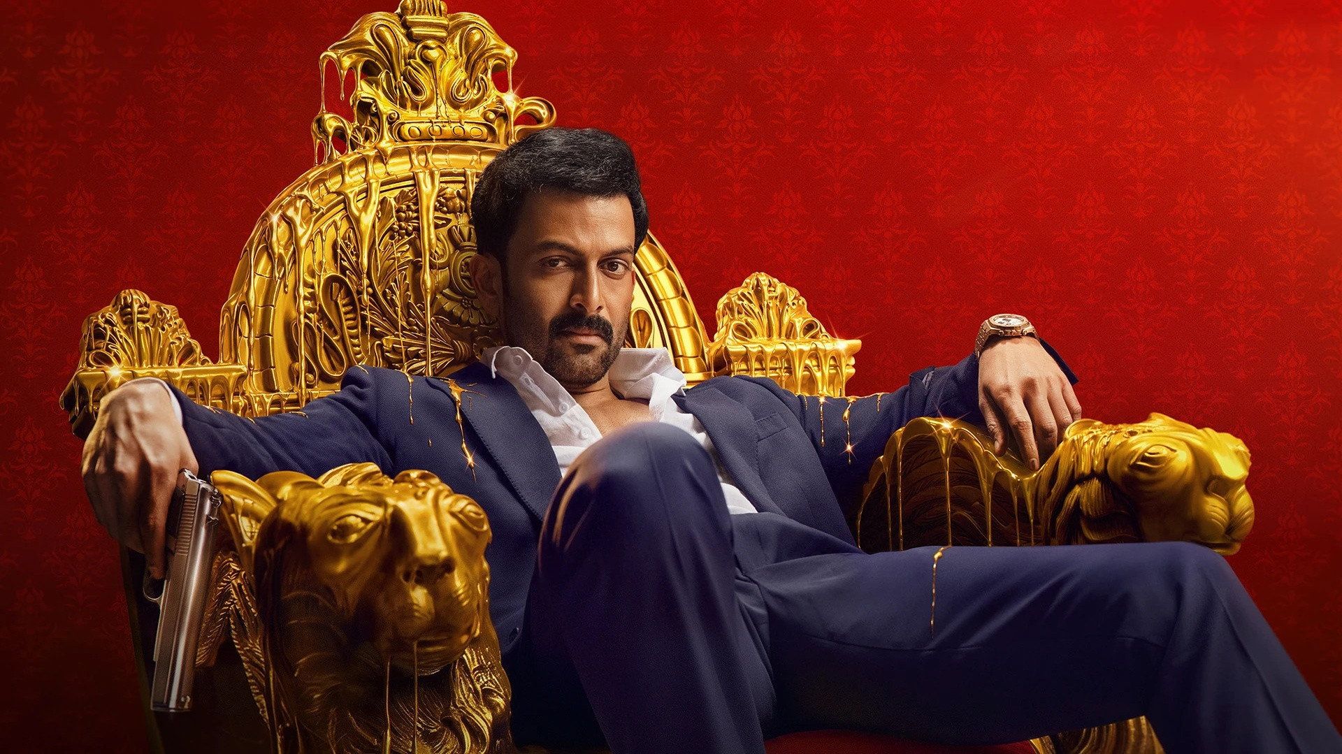 Khalifa still of Prithviraj Sukumaran in a suit seated on an ornate golden throne