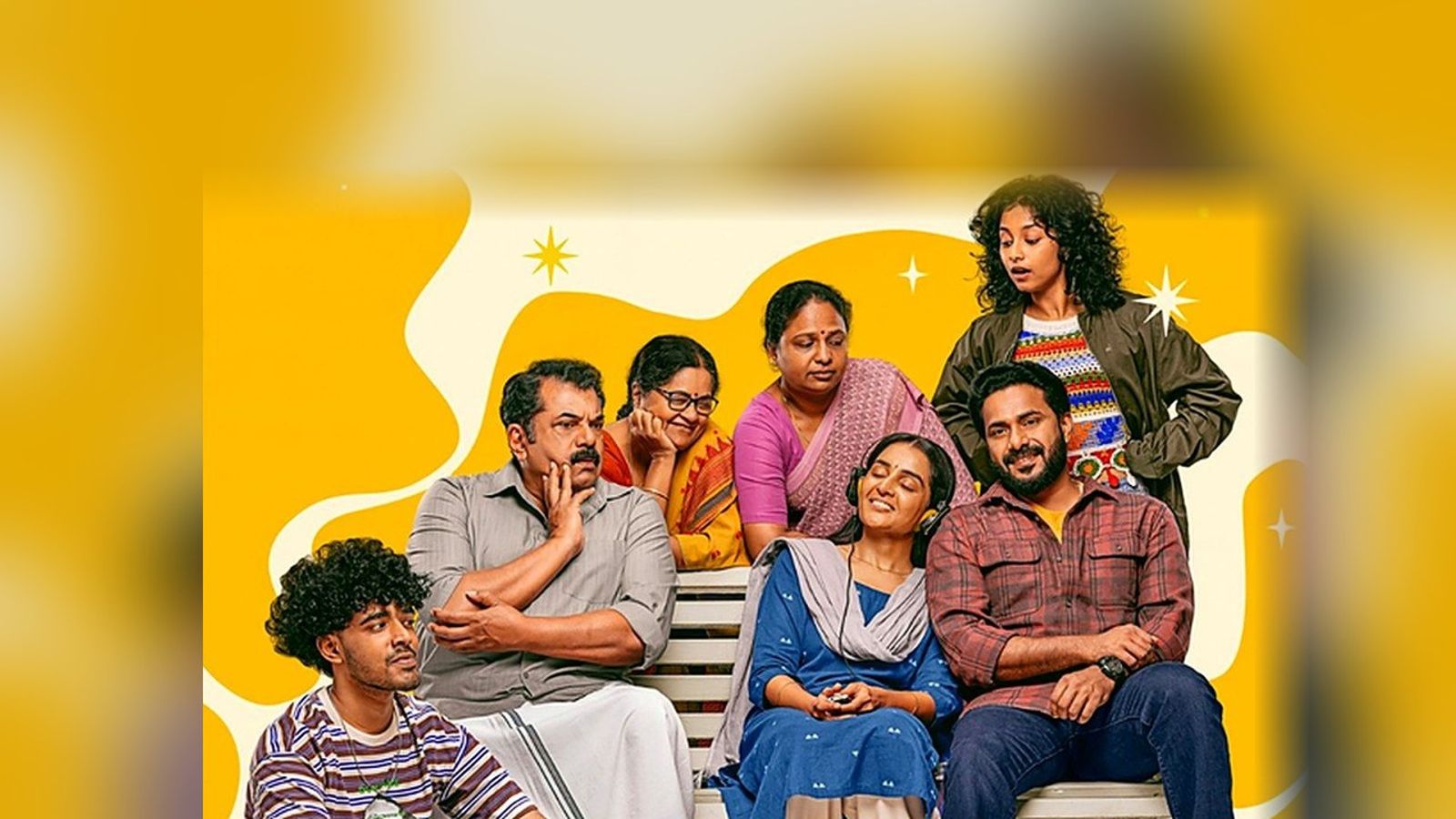 Manju Warrier, Mukesh, JP Thuminad and the cast of Happiloop on a bench in the film's first look poster