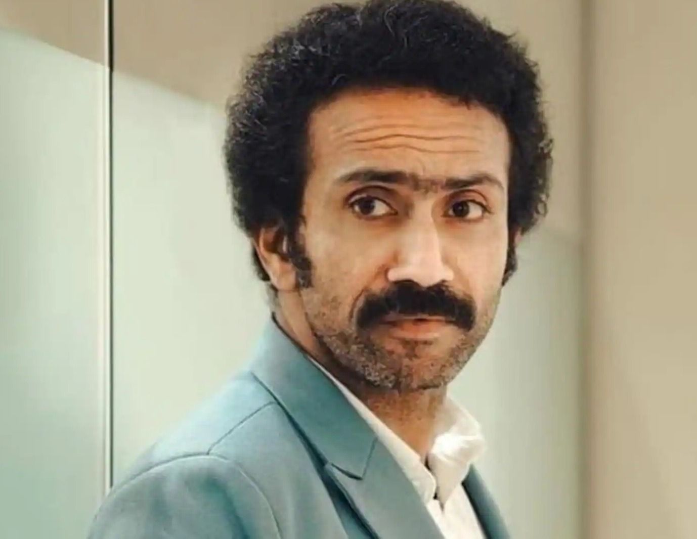 Shine Tom Chacko with a moustache in a teal suit, portrait
