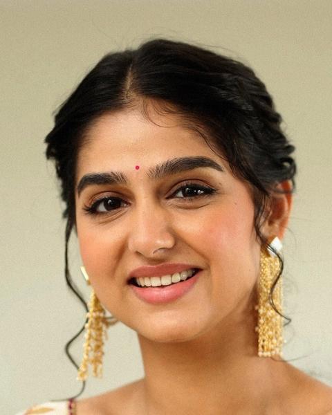Anaswara Rajan smiling with a bindi and gold earrings, close-up portrait