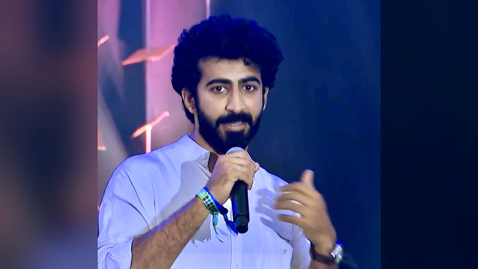 Malayalam actor Roshan Mathew speaking into a microphone on stage