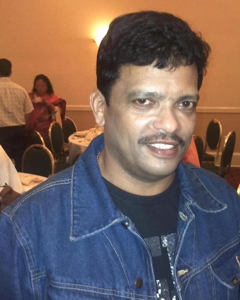 Jagadish smiling in a denim jacket at an indoor event