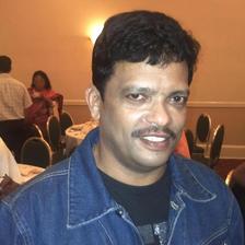 Jagadish smiling in a denim jacket at an indoor event