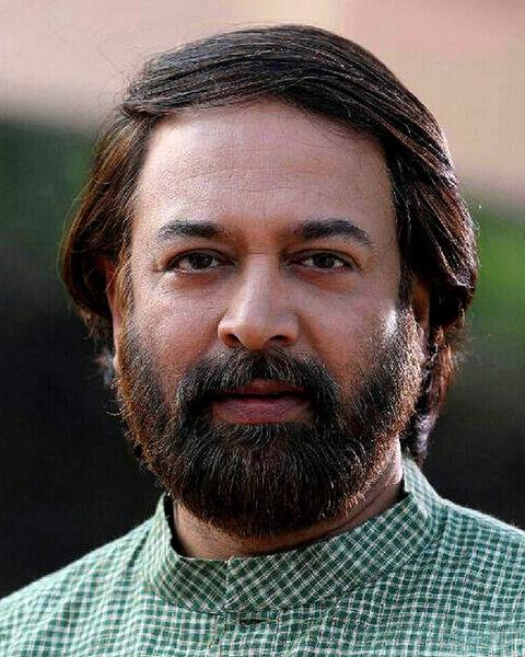 Madhupal with a beard in a green checked shirt, head-and-shoulders portrait